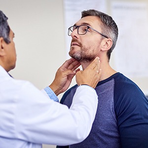 A man getting his throat checked by a dentist