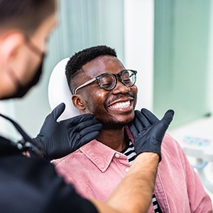 Dentist looking at smiling's patients teeth