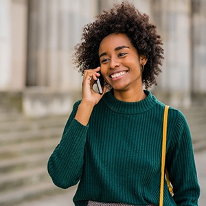 Woman smiling while talking on phone outside