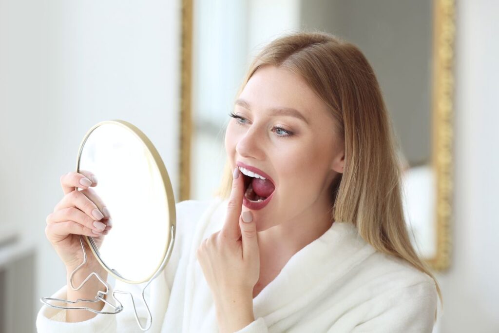 A woman looking in the mirror at her teeth